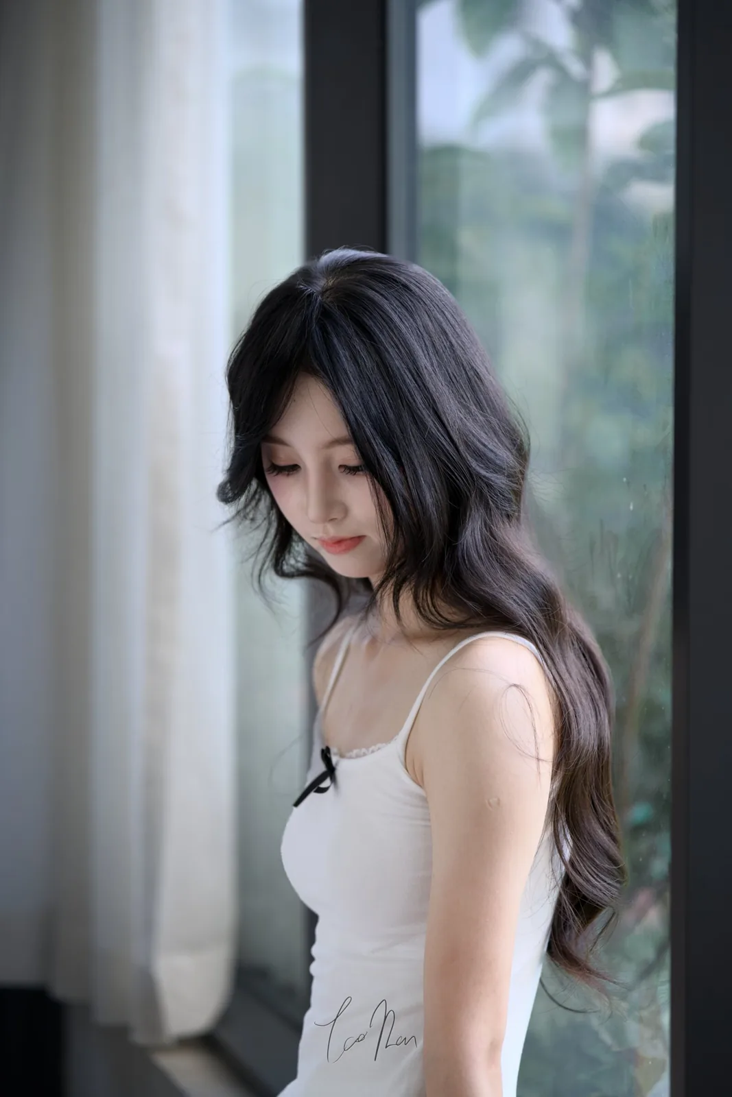 A person in white beside a window