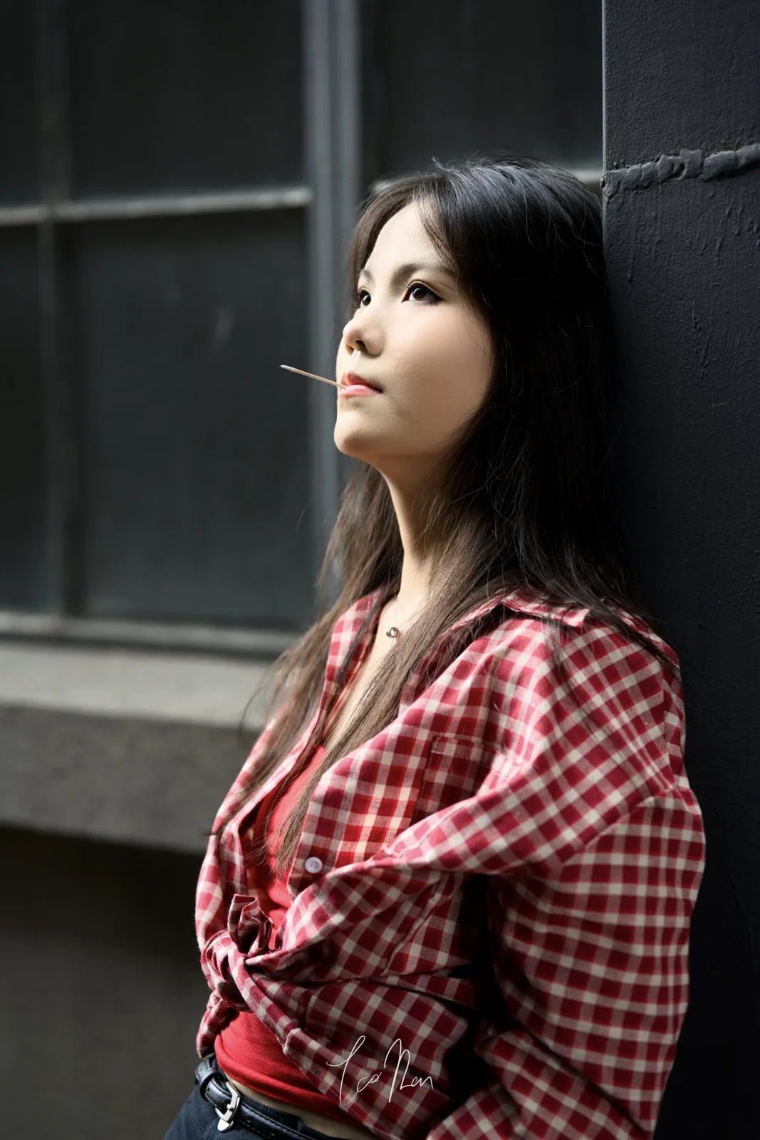 A person looking towards the light beside a window